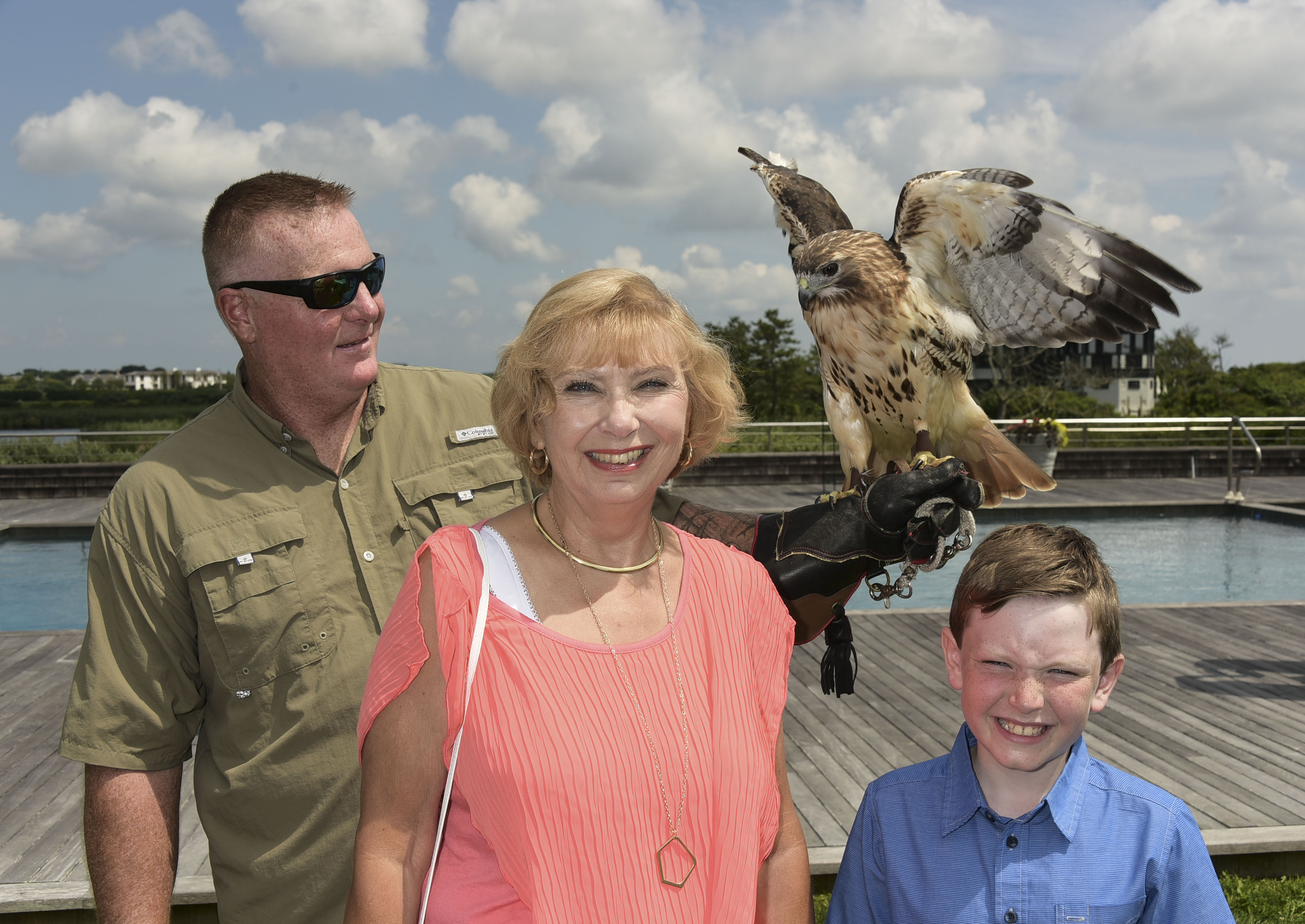 Shane Carter with a Red Tailed Hawk, Christine Molnar, and  Brendyn Molnar pose with the rescued wildlife at  the 11th. Annual Get Wild! Summer fundraiser to benefit the Evelyn Alexander Wildlife Rescue Center of the Hamptons at the private ocean front residence of Liz Brown and Leslie Alexander in Southampton on August 13, 2017. photo by Rob Rich/SocietyAllure.com ©2017